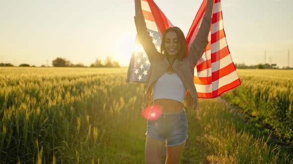 American Woman Proudly Holding American Flag at Sunset Field Celebrate 4Th of July