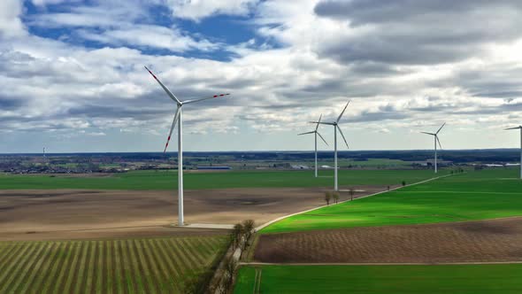 Wind turbines on green field and blue sky, aerial view