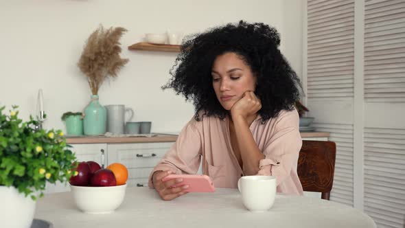 African American Woman Looks at Content on Smartphone Rejoices Celebrating Victory Received Good