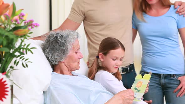 Smiling family standing together around a hospital bed