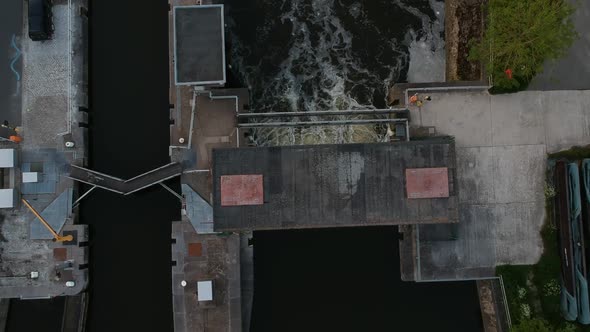 Water flooding out of water lock in top down aerial view