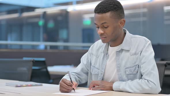 African Man Trying to Write on Paper, Failure