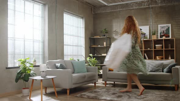 Young Beautiful Woman Happily Spins in the Living Room with White Packages After Shopping