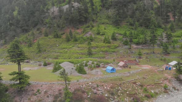 Aerial Of Camp Site Beside Mountainside Beside Riverbank At Kalam Valley In Pakistan. Follow Shot