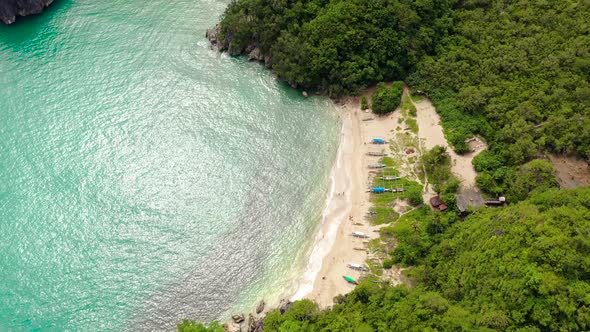 Rocky Island with a Jungle and a Turquoise Lagoon Aerial View