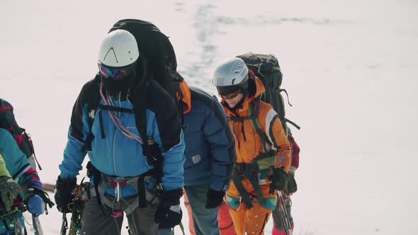 Coordinated Team of Climbers Climb Up the Mountain in Deep Snow Fatigue