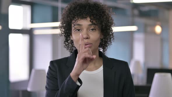 Portrait of African Businesswoman Asking To Be Quiet By Putting Finger on Lips