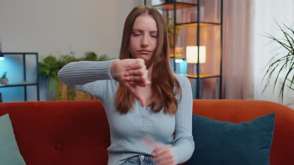 Upset Young Woman Showing Thumbs Down Dislike Bad Work Disapproval Dissatisfied Feedback at Home