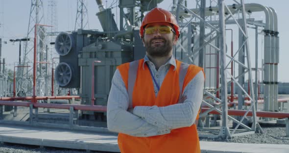 Mature Foreman Crossing Arms on Power Plant