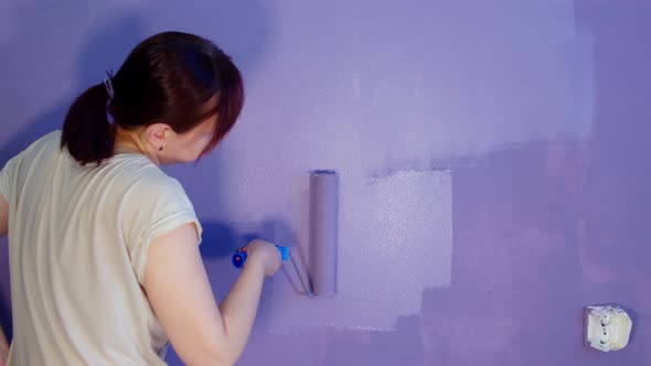 Close Up of Unrecognizable Person Painting Wall in Purple Colour with Roller