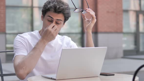 Young Man with Headache Working on Laptop, Sitting Outdoor