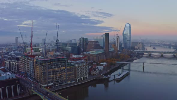 Falling crane drone shot of southwark Blackfriars thames river bank at sunrise