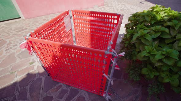 Red Plastic Fence of Sewer Manhole in Sunny Burano Street