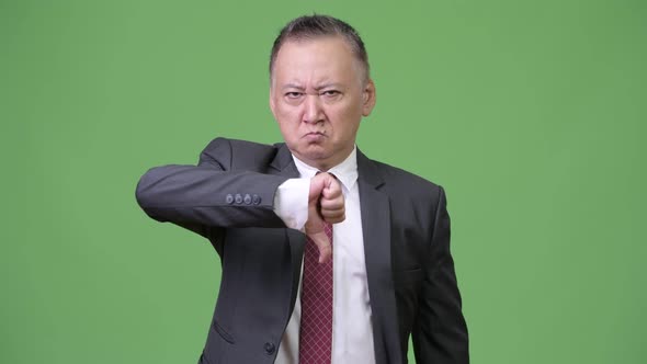 Mature Japanese Businessman Giving Thumbs Down