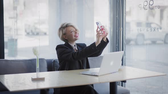 Blonde Woman in a Cafe with a Phone