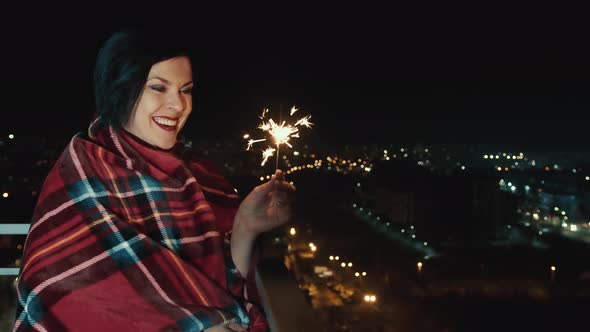 Woman Alone at Night with Sparkler in Hand and Smiling