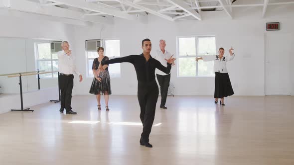 mixed race male dance teacher taking a ballroom dancing class at a dance studio