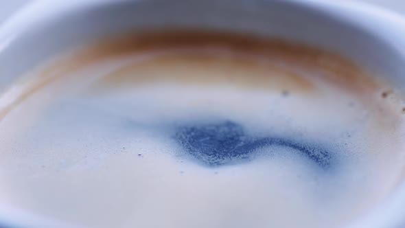 Drop of Coffee Falls Into the Filled Cup