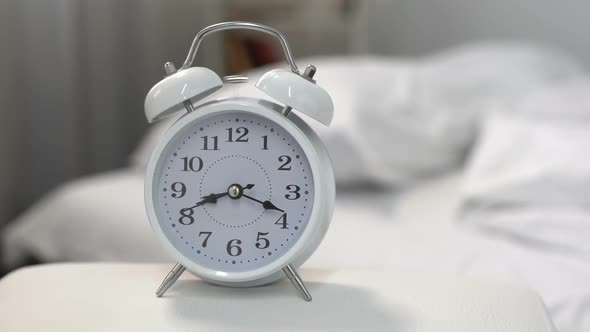 Bed Clock Showing Midnight Near Sleeping Man in Bed