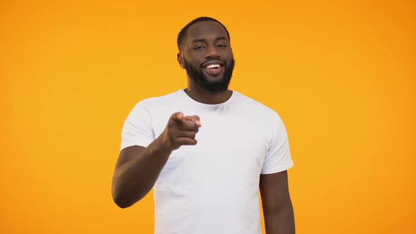 African American Man Pointing Finger at Camera and Winking, Smiling Knowingly