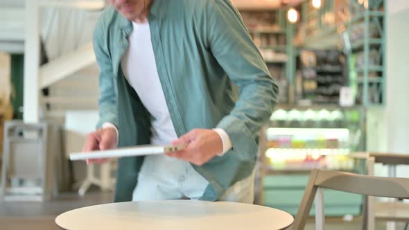 Middle Aged Man Closing Laptop and Walking Away in Cafe