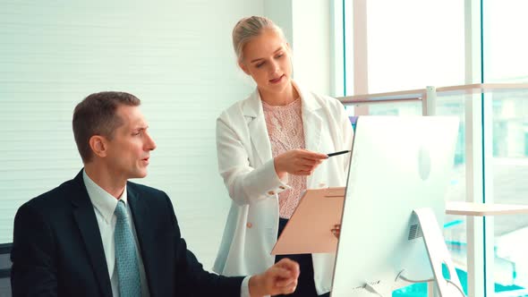 Two Business People Talk Project Strategy at Office