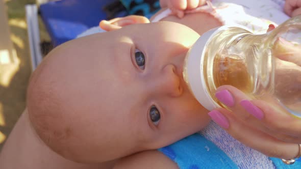 Baby Lying on Mothers Lap and Drinking From the Bottle