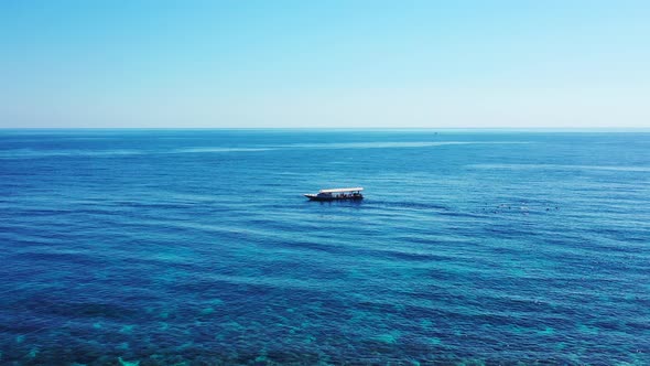 tourists snorkeling in the open sea near the tour boat. aerial seascape, watersport concept. Belize