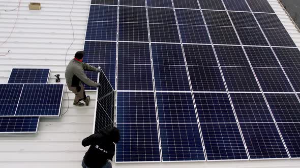 Solar Technician Installing Solar Panels on House Roof