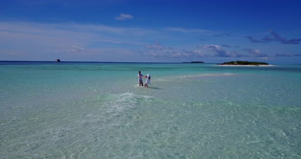 Happy man and woman on romantic honeymoon enjoy luxury on beach on sunny white sandy background