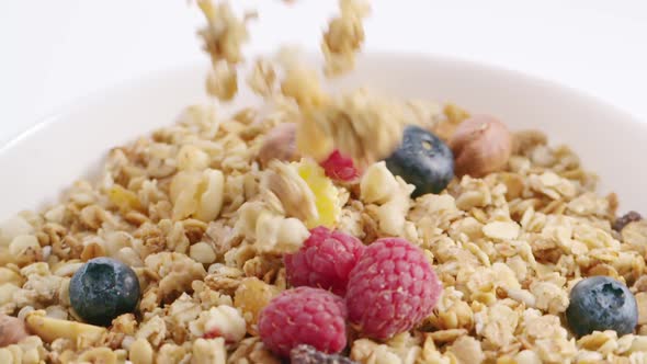 Muesli with Corn Flakes Berries and Nuts Throwing Into the Bowl