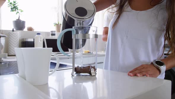 Young woman preparing coffee in kitchen at home 4k