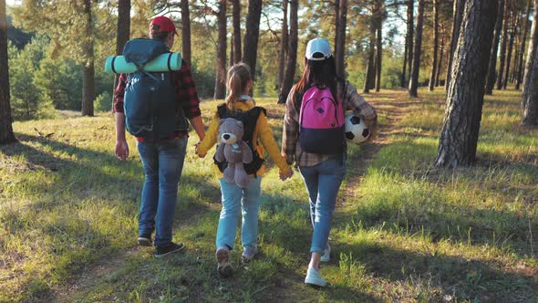 Happy Family Hiking Through a Forest