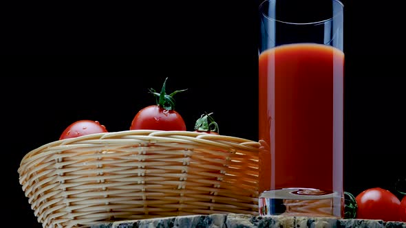 Pour Natural Tomato Juice Into A Glass On A Black Background. Fresh Tomatoes With Tomato Juice