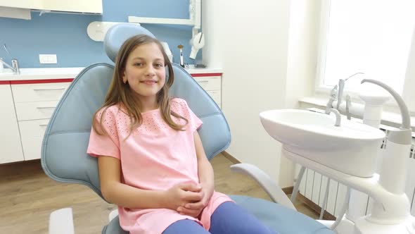 Close up of little girl sitting in the dental chair and smiling