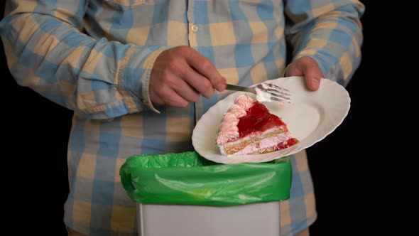 Man Scraping with a Plate a Strawberry Cake Into Garbage Bin