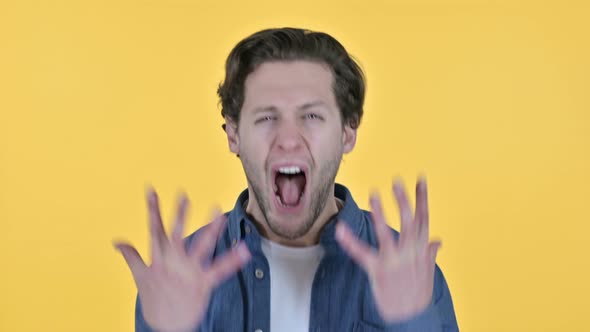 Irritated Young Man Shouting, Screaming on Yellow Background