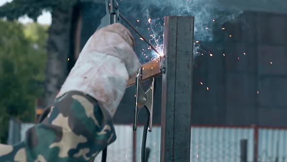 Slow Motion Closeup Builder Welds Fence with New Equipment