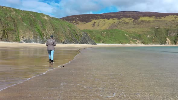 Lady Walking on the Beautiful Beach at Malin Beg in County Donegal  Ireland