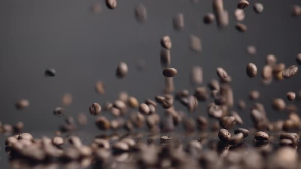 Brown Coffee Grains Falling on Surface Bouncing Closeup