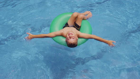 Boy in pool swimming with innertube.  Shot on RED EPIC for high quality 4K, UHD, Ultra HD resolution