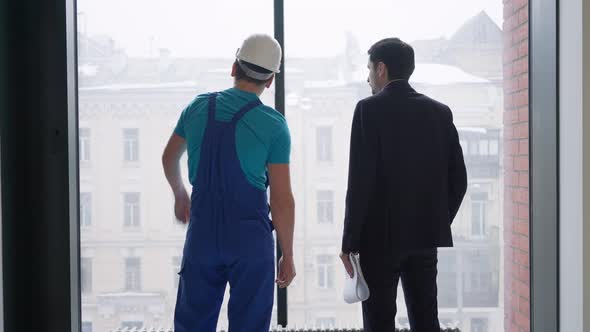 Young Confident Builder and Buyer Shaking Hands Standing at Window Indoors