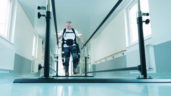 A Man is Using Exoskeleton to Practice Walking