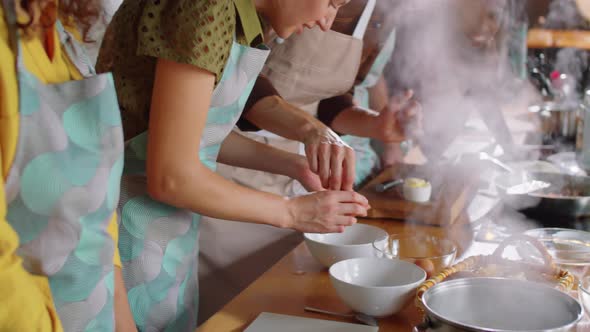 Woman Separating Egg Yolk with Help of Chef on Cooking Master Class