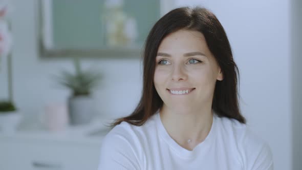 Portrait of happy brunette woman looking at the camera