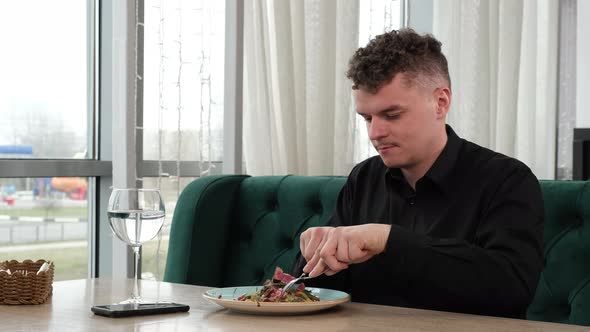 A Young Man is Having Lunch in a Restaurant