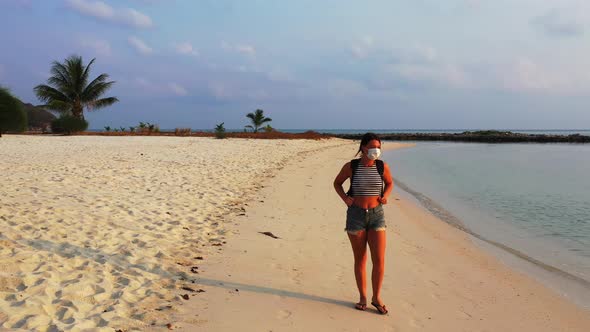 Beautiful happy ladies on photoshoot by the sea at the beach on summer white sand and blue backgroun