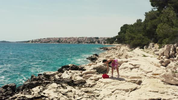 Aerial View Girl Came to Sunbathe on a Rock By the Sea