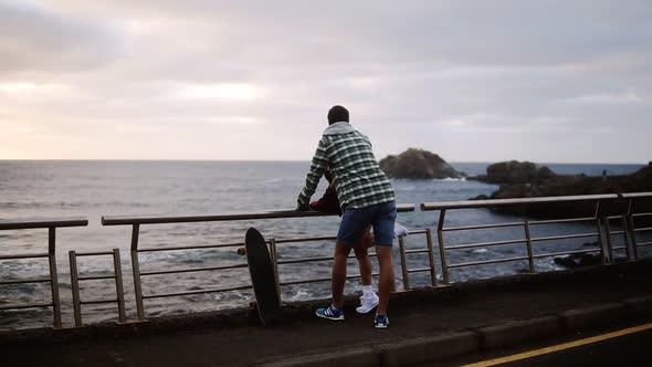 Woman and Standing Together Looking on Ocean Young Couple Shown From the Side Look Out Over an Ocean