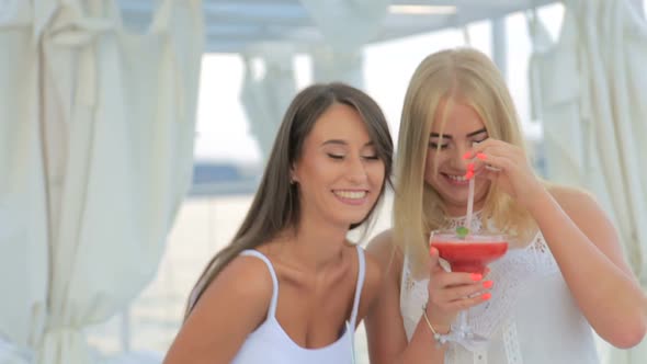 Attractive Girls Drinking Cocktails on the Beach and Having a Good Time